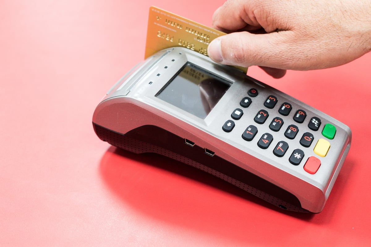 hand with dataphone paying and charging with credit card