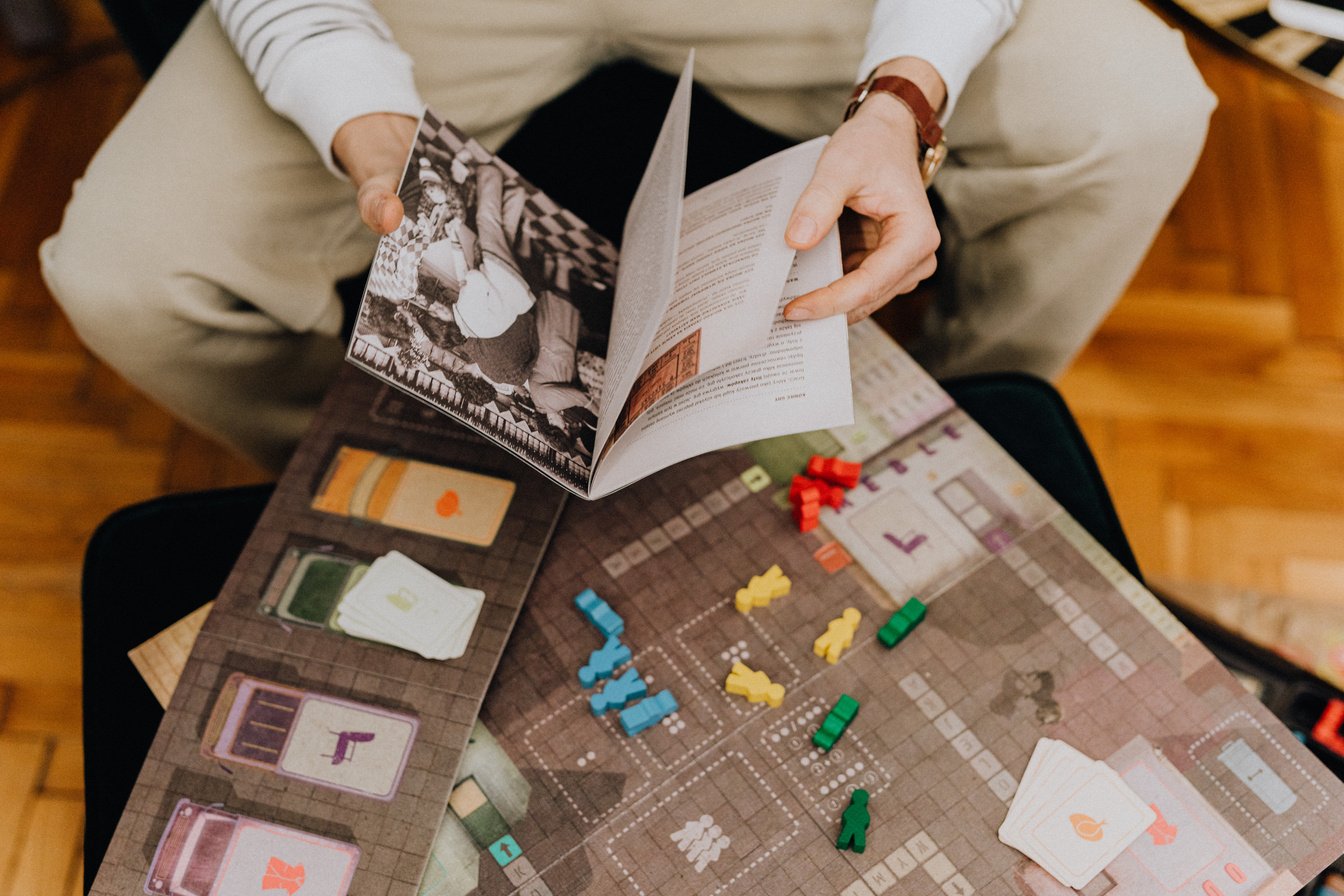 Person Reading Board Game Instruction 